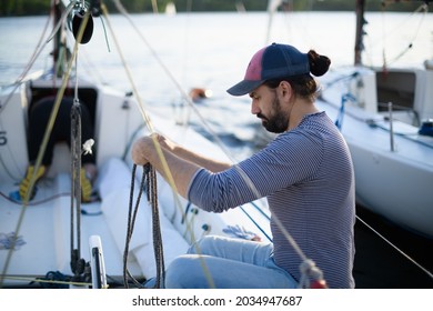 Preparation for the regatta at the yachting school at the marina with sailing yachts. Students and coaches prepare moored sports yachts for sailing on a sunny summer day. - Powered by Shutterstock