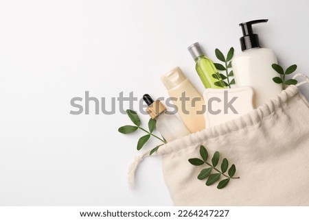 Preparation for spa. Compact toiletry bag, twigs and cosmetic products on white background, flat lay. Space for text