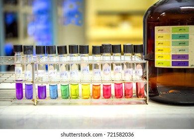 Preparation Of Standard PH Solution, Matching The Color Of The Bottle With The Universal Chemical Indicator  In Chemistry Laboratory. Close Up Image.