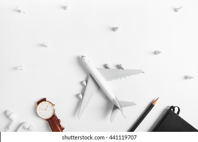 Preparation for Traveling concept, watch, airplane, pencils, book, earphone, push pin, on white background with copy space.