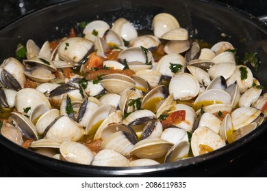 Preparation Of Vongole Mussels For Spaghetti Alle Vongole, Iron Pan On A Stovetop With Dark Background. Italian Mediterranean Sea Food