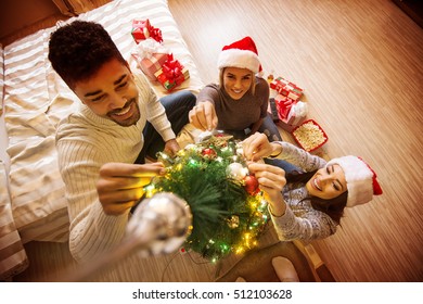 Preparations for holidays. Young friends decorating Christmas tree. - Powered by Shutterstock