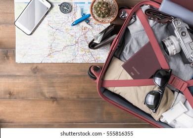 prepare accessories and travel items with map on wooden board, flat lay, top view background