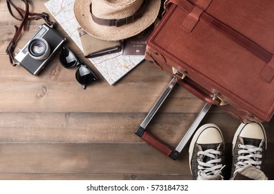 Prepare Accessories And Travel Items On Brown Wooden Board, Flat Lay, Top View Background