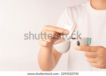 Prepare asthma inhaler for use. Woman hands put Tiotropium bromide capsule in chamber of inhaler and close mouthpiece. Pharmaceutical products is used to treatment COPD and asthma. 
