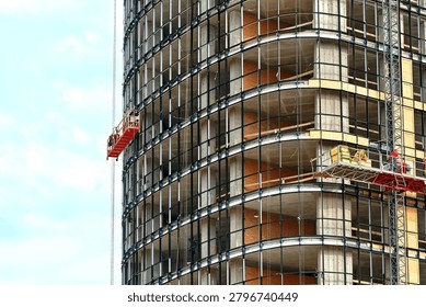 Prepare building for structural glazing, workers on suspended platforms create all-glass facade of residential building. Curtain wall system, glass panel installation. Glazing high-rise building