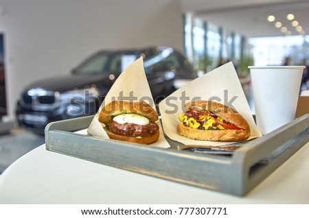 Prepare delicious burger with fried meat cutlet placed on a table in wooden tray, diagonally placed