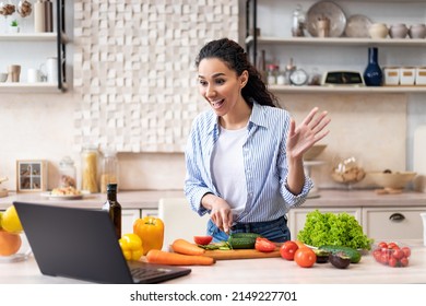 Prepare Food At Home. Excited Lady Preparing Salad, Cutting Vegetables And Talking On Video Chat With Family Via Laptop Computer, Cooking In Light Kitchen