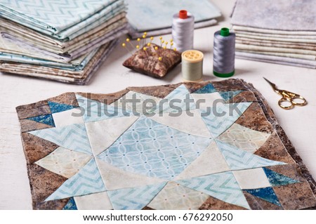 Prepared blocks for sewing quilt, stack of fabrics, sew accessories