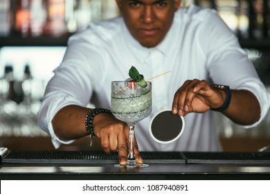 Prepared Cocktail By A Mixed Race Male Expert Bartender Holding A Coaster Is Placed At The Bar Counter