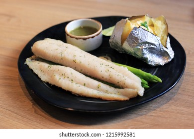 Prepared Grilled Basa Fish Fillet With Baked Potatoes And Seafood Dipping Sauce. Diet Food Menu Steak For Healthy Lifastyle.