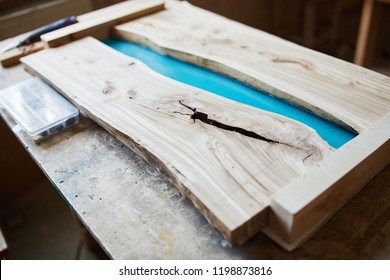 Prepared wooden table top for epoxy resin on working desk in joinery shop