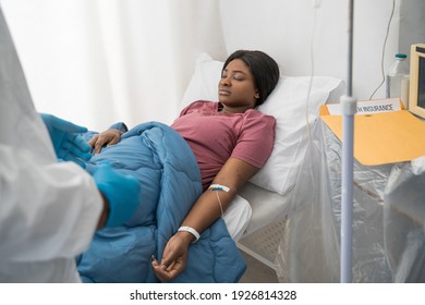 Preparing all for treatment. Cropped view of the skilful doctor wearing protective equipment preparing to treatment for his female patient with covid 19 disease. Stock photo - Shutterstock ID 1926814328