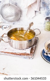 Preparing Base Soup Recipe. Pot Of Chicken Stock Soup Over Kitchen Grey Table. 