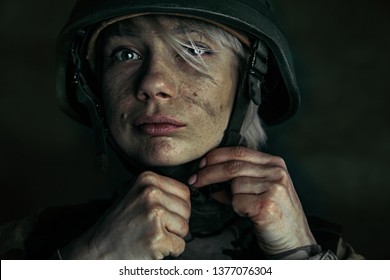 Preparing for being stronger like a stone. Close up portrait of young female soldier. Woman in military uniform on the war. Depressed and having problems with mental health and emotions, PTSD.
