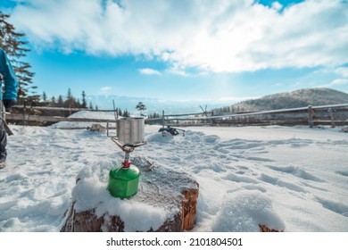 Preparing Boiling Tea Or Coffee On Primus Camping Gas Stove. Traveler Resting With A Metal Mug Of Hot Tea On A Cold Winter Day.  Adventure Begins Boiling On Gas Primus, Making Hot Drink Winter Outdoor