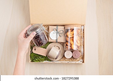 Preparing Care Package, Seasonal Gift Box With Coffee, Cookies, Candles And Cup. Personalized Eco Friendly Basket For Family And Friends For Thankgiving, Christmas, Mothers And Fathers Day Holidays. 