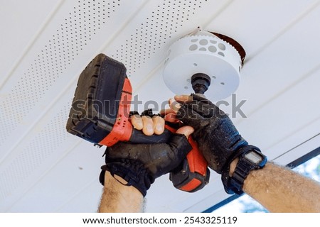 Preparing ceiling for installation of a new light fixture with using cordless drill