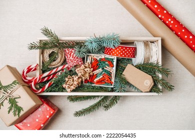 Preparing For Christmas Holidays. Xmas Gift Wrapping Party Time With Colorful Paper, Ribbon Bows, And Tape In Wooden Box. Staff For Wrapping Christmas Gift Boxes, Top View