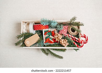 Preparing For Christmas Holidays. Xmas Gift Wrapping Party Time With Colorful Paper, Ribbon Bows, And Tape In Wooden Box. Staff For Wrapping Christmas Gift Boxes, Top View.