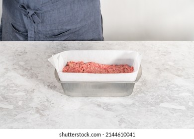 Preparing Classic Meatloaf In A Loaf Pan Lined With Parchment Paper.