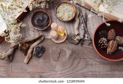 Preparing cosmetic black mud mask on vintage wooden background. Top view of facial clay on table with sea salt, spa products and dry flowers. Natural cosmetics for home or salon treatment, copy space - Shutterstock ID 1218939694