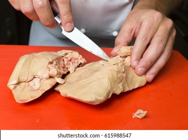 Preparing And De Veining Foie Gras On A Red Cutting Board.