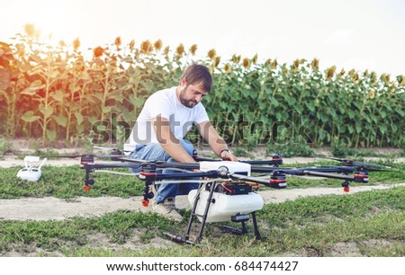 Preparing a drone for take off despite the sunset. Octocopter flights outdoors, aerial imagery and tech hobby, recreation concept.