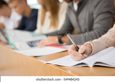 Preparing For Exams. Cropped Closeup Of Group Of Students Sitting In A Row Writing During The Lecture Education Studying Campus College High School University Teen People Team Together Concept