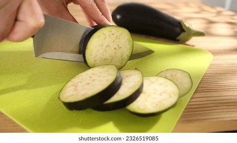 preparing fresh vegetables. slicing eggplant on a cutting board. healthly food. sunny day. - Powered by Shutterstock