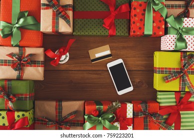Preparing for holidays background. Gift boxes frame, mobile and credit card on wood. Seasonal sales, online shopping, presents for any holiday concept. Top view, flat lay, copy space