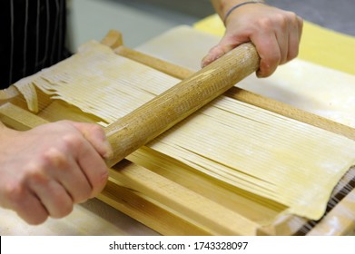preparing homemade spaghetti with egg pasta called spaghetti alla chitarra from the name of the tool used to cut the pasta, typical product of Abruzzo region in central Italy