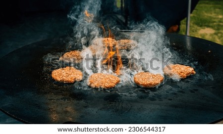 Preparing juicy beef hamburger patties . BBQ meat sizzling over hot flames.