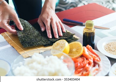 Preparing Nori Seaweed While Making Sushi On The Home Kitchen Table