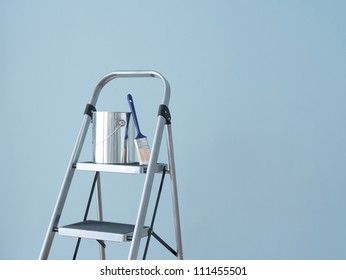 Preparing To Paint The Wall. Painting Tools On A Metal Ladder.