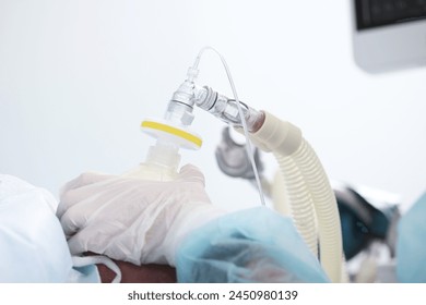 Preparing the patient for surgery. Introduction to anesthesia. A breathing mask in the hands of a doctor. General anesthesia.