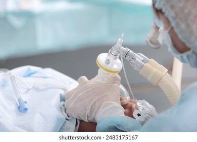 Preparing the patient for surgery. Introduction to anesthesia. General anesthesia. A breathing mask in the hands of a doctor