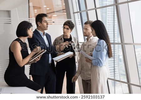 Preparing for presentation. Confident mid aged businessman ceo director team leader speak to multiethnic diverse workmates set tasks explain strategy plan before presenting group project on conference