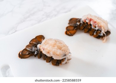 Preparing raw lobster tails to make garlic lobster tails. - Shutterstock ID 2258588559