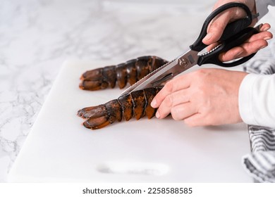 Preparing raw lobster tails to make garlic lobster tails. - Shutterstock ID 2258588585