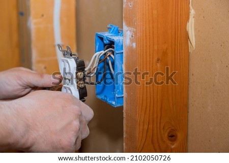 Preparing to remove an electrical outlet of the screws for electrical wires receptacle plug panel