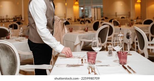 Preparing restaurant table for guest by waiters