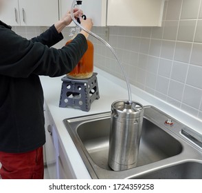 Preparing To Siphon Beer From One Gallon Carboy To Mini Keg.  Home Brewing Concept.           