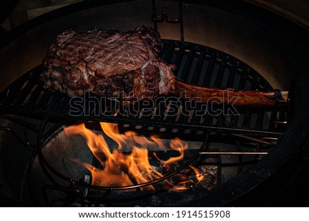 preparing a tomahawksteak on the barbecue