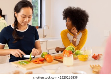 Preparing vegetables, diverse friends cooking together in modern kitchen. teamwork, culinary, fun, preparation, lifestyle - Powered by Shutterstock