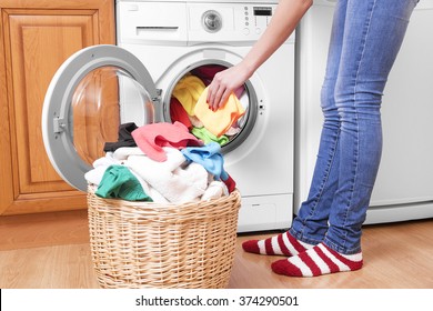Preparing the wash cycle. Washing machine, hands and clothes.