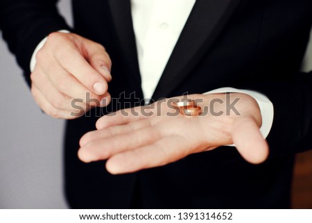 Preparing for wedding. Groom buttoning cufflinks on white shirt before wedding. True men's accessory. Groom's clothes.