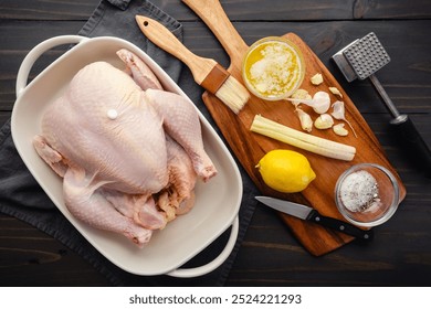 Prepping Vietnamese Roasted Chicken: Whole chicken with crushed lemongrass stalk and garlic cloves , whole lemon, and melted butter - Powered by Shutterstock