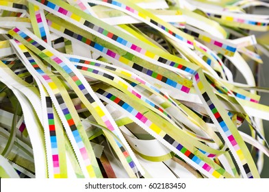 Prepress color management in print production. CMYK color stripes cut on printed paper. Quality printing concept