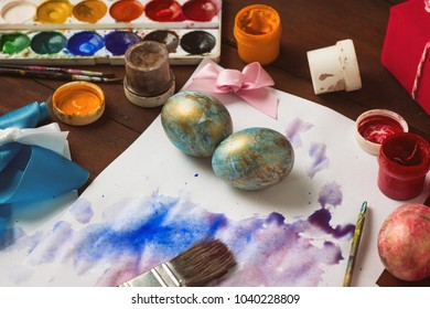 Preprimary painting of Easter Eggs, Brushes, Paints, Eggs on the Dark Wooden Table. Easter concept.